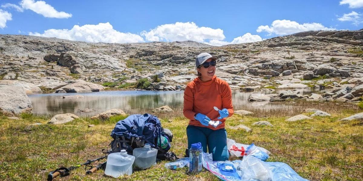 MJ Farruggia processes water samples at the shore of a pond in Sequoia National Park.