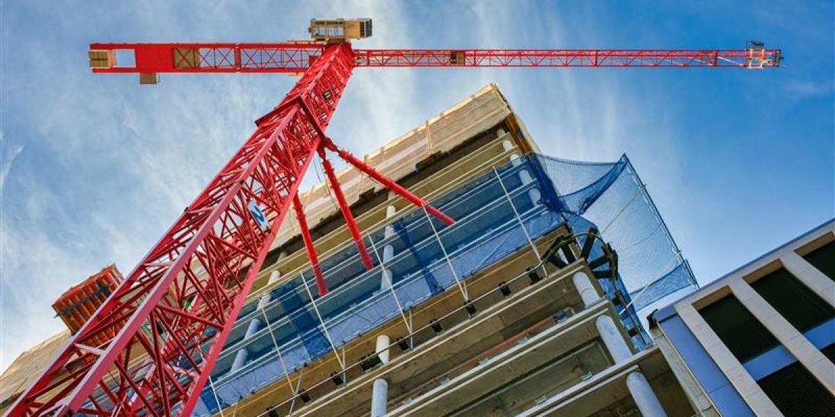 A crane stands beside a building under a construction