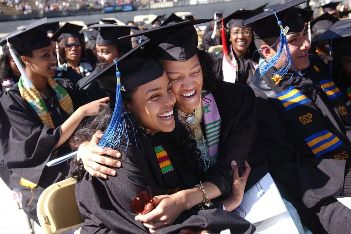 Graduating students hugging each other at commencement
