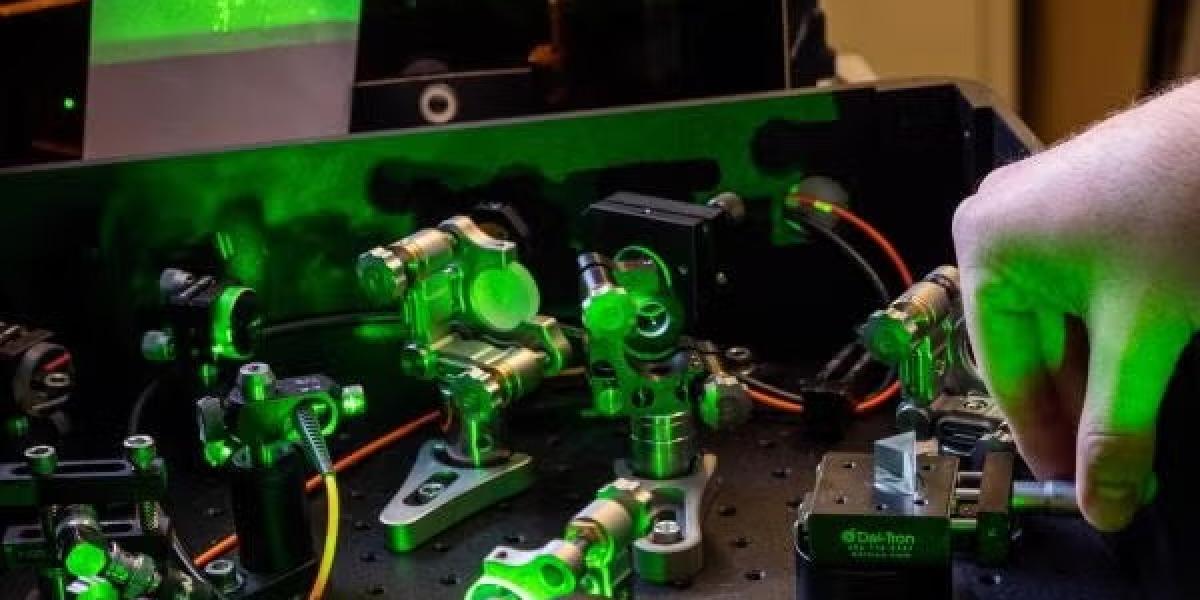 Close-up of a hand working on a machine lit by green light